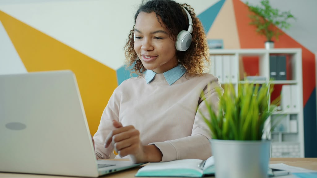 Teen with headphones learning on her laptop
